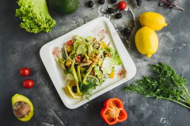 Karanlık tablo taze sebze, avokado, limonlu salata. Düz ile lezzetli yemekler yatıyordu