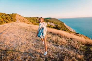 Çekici gülümsüyor kadın sıcak gün batımında açık. Dağlarda mutlu tatil