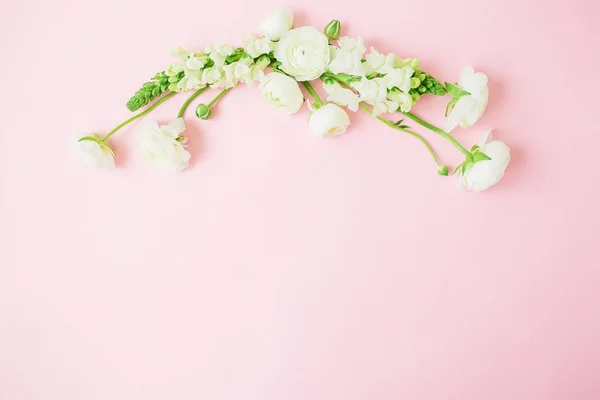 Floral pastel frame made of white flowers on pink background. Flat lay, top view. Floral background.