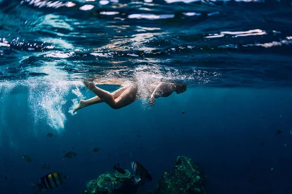 Woman swim in the tropical ocean at shipwreck