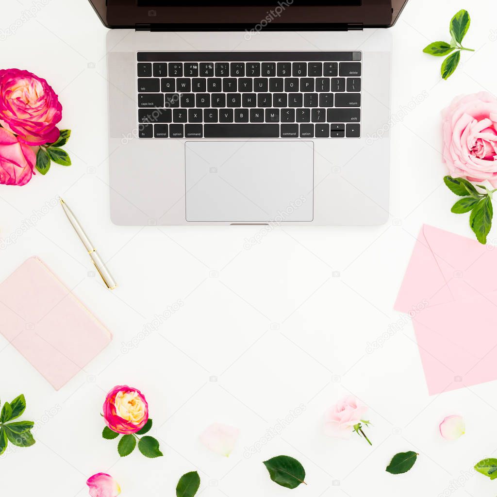 Laptop, roses flowers, diary, pen and envelope on white background. Flat lay. Top view. Feminine composition with copy space