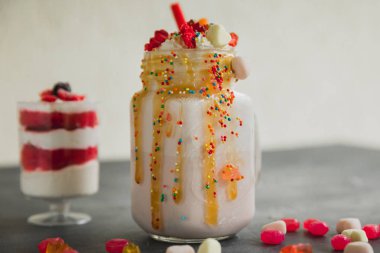 Pembe tek boynuzlu at milkshake sosu ve şeker damlayan çırpılmış krema ve tatlı tatlı ile