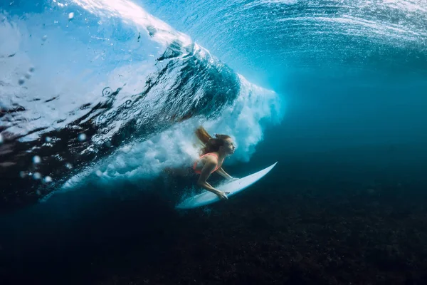 青い海でバレルの波の下で 魅力的なサーファー女性が潜ったり — ストック写真