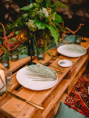 Masa dekor, tabaklar, mumlar ve bitki. Düğün yemeği