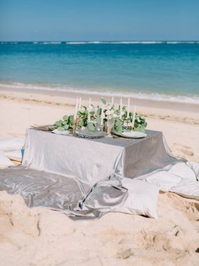 Düğün masa, çatal bıçak takımı, mumlar ve bitki. Düğün yemeği tropikal plaj