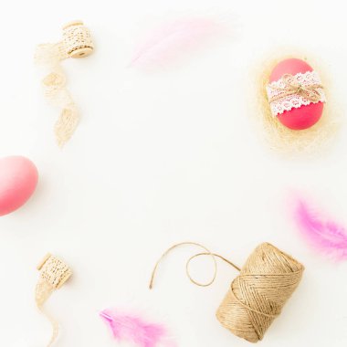 Paskalya günü. Pembe yumurta sicim, tüyler ve beyaz arka plan, üstten görünüm kasetlerde çerçeve yapılmış