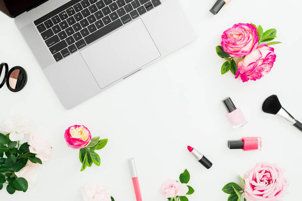 Laptop, roses flowers, cosmetics isolated on white background. Flat lay. Top view. Frame composition with copy space