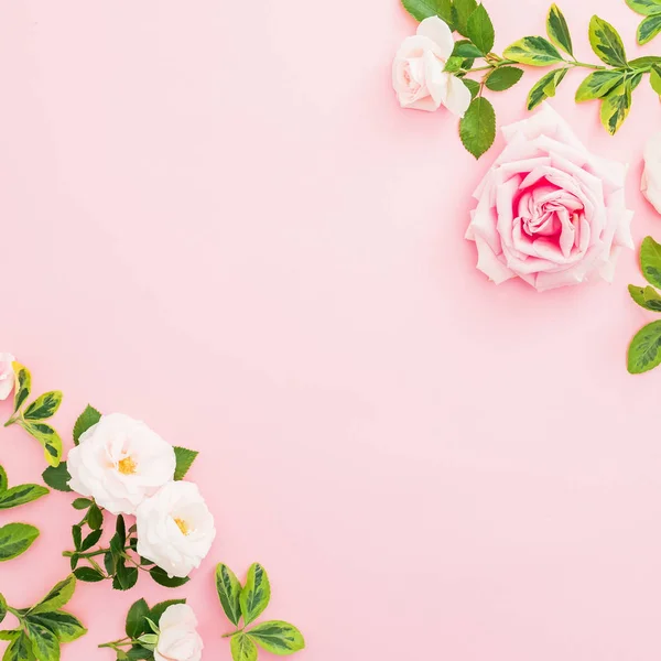 stock image Floral frame with roses and leaves on pastel pink background. Flat lay, top view.