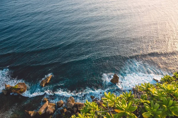 Blue ocean with waves, rocks and cliff