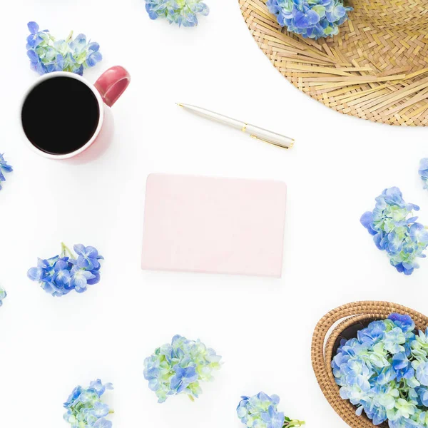 Saman, günlüğü ve kupa kahve beyaz zemin üzerine mavi çiçekler bileşimi. Düz yatıyordu, en iyi görünüm. Çiçek arka plan