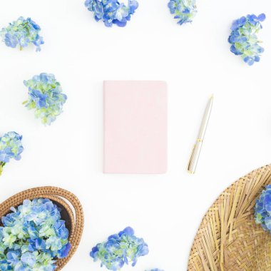 Saman, günlüğü ve kupa kahve beyaz zemin üzerine mavi çiçekler bileşimi. Düz yatıyordu, en iyi görünümü.