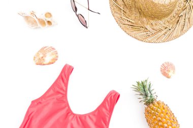 Tatil kavramı. Ananas meyve, güneş gözlüğü, hasır şapka ve beyaz arka plan üzerinde pembe mayo çerçeve. Düz yatıyordu, en iyi görünümü.