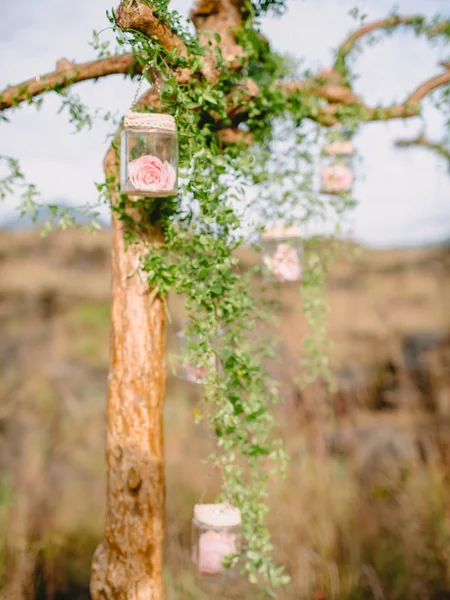 Floral decoration for wedding ceremony. Rustic arch with pink flowers.