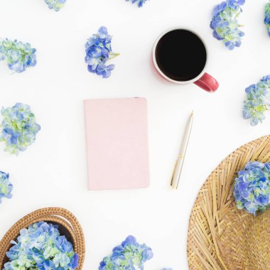 Saman, günlüğü ve kupa kahve beyaz zemin üzerine mavi çiçekler bileşimi. Düz yatıyordu, en iyi görünüm. Çiçek arka plan