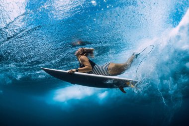 Surfgirl sörf tahtası dalış sualtı ile dalga okyanus altında ile.