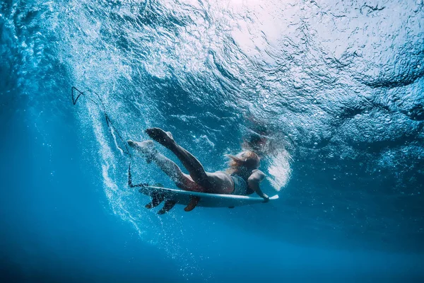 波の下で楽しいサーフボード ダイビング 水中でサーファーの女の子 — ストック写真