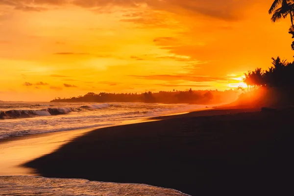 明るい夕日や海の波やバリ ギニャール ビーチでヤシの木と日の出 — ストック写真
