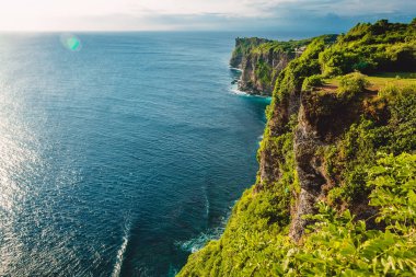 Mavi okyanus ve cliff Uluwatu, Bali ağaçlarda ile