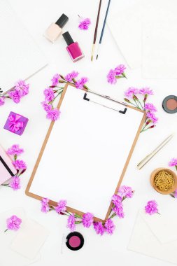Blogger çalışma alanı Pano, defter, pembe çiçek ve aksesuar beyaz arka plan üzerinde. Düz yatıyordu, en iyi görünümü.