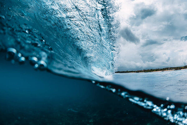 Голубая бочка в океане. Разрывающаяся волна и облачное небо
