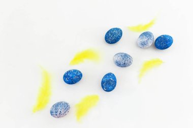 Paskalya yumurta beyaz arka plan üzerinde kuş tüyleri ile. Düz yatıyordu, en iyi görünümü