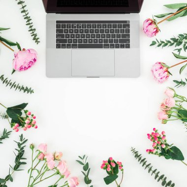 Beyaz arka plan üzerinde laptop ve pembe çiçekli çiçek kompozisyon. Üstten Görünüm. Düz yatıyordu.