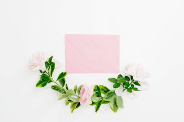 Pembe güller ve beyaz zemin üzerine yeşil yaprakları çiçek kompozisyon zarf. Düz yatıyordu, en iyi görünümü