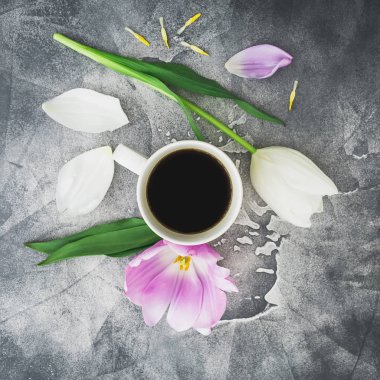 Lale, yaprakları ve koyu arka plan üzerinde kupa kahve kahvaltı kompozisyonu. Düz yatıyordu, en iyi görünümü.