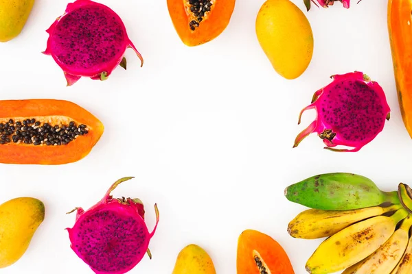 Fruits frame with banana, papaya, mango and dragon fruits on white background. Flat lay. Top view. Tropical fruit concept