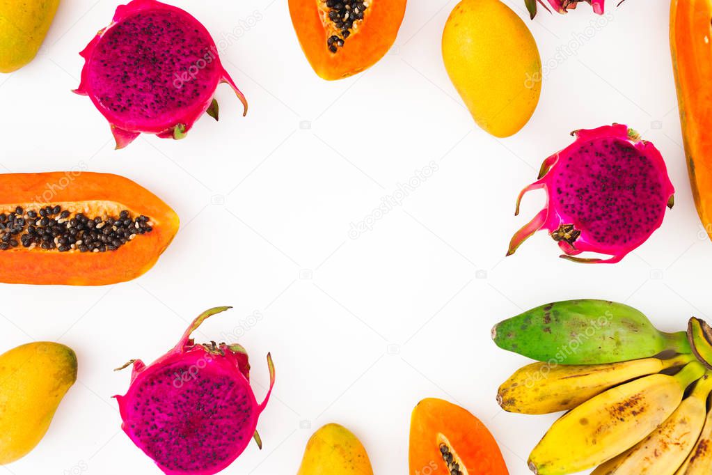 Fruits frame with banana, papaya, mango and dragon fruits on white background. Flat lay. Top view. Tropical fruit concept