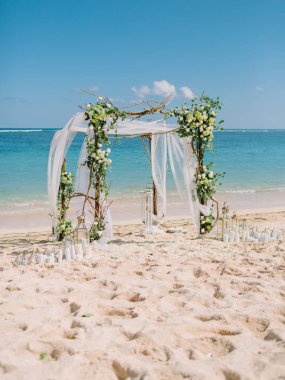 Wedding arch with white flowers at blue ocean in tropical island. Wedding ceremony. clipart