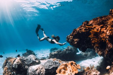 Kadın freediver yüzgeçleri ve mercan ile. Serbest dalış sualtı mavi okyanus