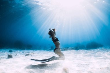 Kadın freediver yüzgeçleri ile kumlu deniz üzerinde poz ile. Serbest dalış sualtı Hawaii