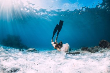 Kadın freediver kum kumlu deniz yüzgeçleri ile üzerinden. Serbest dalış sualtı mavi okyanus