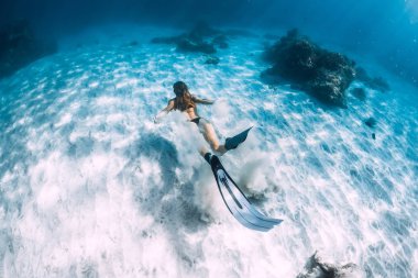 Kadın freediver kum kumlu deniz yüzgeçleri ile üzerinden. Serbest dalış sualtı Hawaii