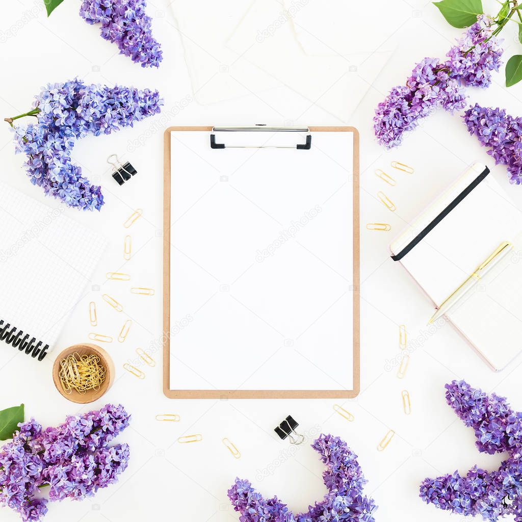 Feminine composition with clipboard, diary, lilac and accessories on white background. Flat lay, top view.