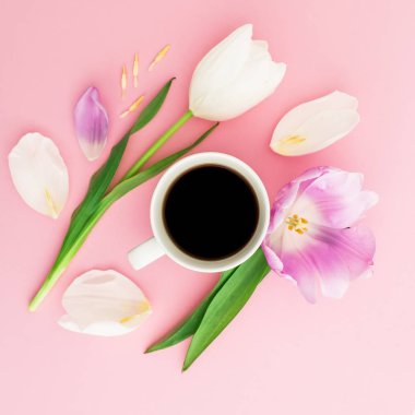 Çiçek, yaprakları ve pembe pastel arka plan üzerinde siyah kahve bir fincan. Düz yatıyordu, en iyi görünümü.