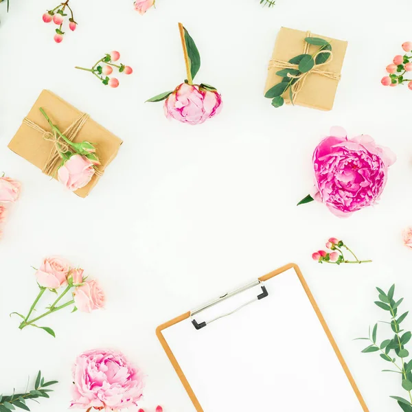 Pembe peonies, gül, hypericum ve okaliptüs Pano ve beyaz arka plan üzerinde hediyeler ile oluşan çerçeve çiçek. Düz yatıyordu, en iyi görünümü
