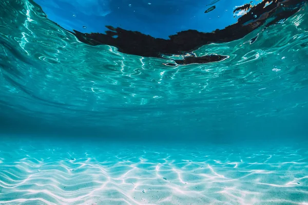 Tropical blue ocean with white sand underwater in Hawaii