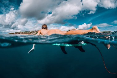 Kız yüzen üzerinde sörf sörf. Çıplak kadın sörf sırasında. Sörfçü ve okyanus