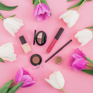 Lale ve pembe bir arka plan üzerinde kozmetik güzellik kompozisyonu. Üstten Görünüm. Düz yatıyordu.