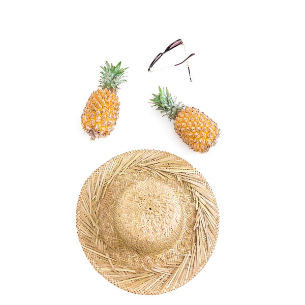 Holidays concept. Pineapple fruits, glasses and straw hat on white background. Flat lay