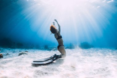 Kumlu alt sualtı Okyanusu üzerinde poz yüzgeçleri ile Freediver genç kadın
