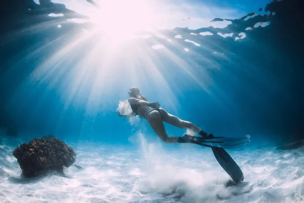 有吸引力的妇女自由潜水员与白色的沙子在手在沙滩与鳍 在海洋中的水下自由潜水 — 图库照片