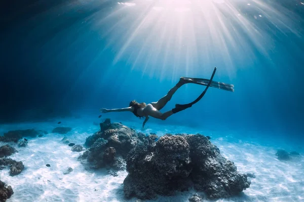 女性フリーダイバは 砂の海の上にフィンでグライド ブルーオーシャンでフリーダイビング — ストック写真