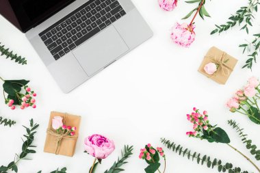 Beyaz arka plan üzerinde laptop ve pembe çiçekli Office çalışma alanı. Üstten görünüm. Düz yatıyordu.