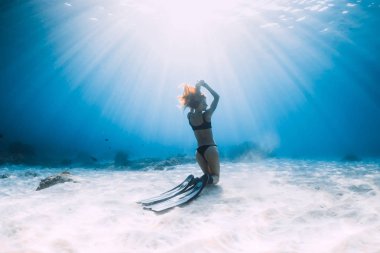 Kumlu denizin üzerinde yüzgeçleriyle poz veren özgür bir kadın. Hawaii 'de serbest dalış
