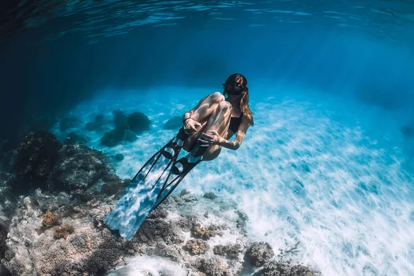青い海でフィンを持つ女性のフリーダイバーが泳ぐ 海に潜る — ストック写真