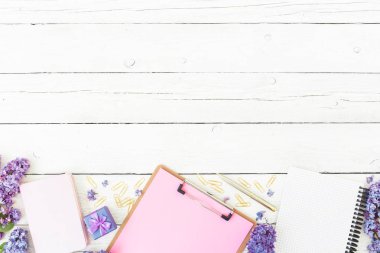 Pano, günlük, leylak çiçekleri, hediyelik eşya ve ahşap arka plan üzerine aksesuarlar ile kompozisyon. Düz yatıyordu