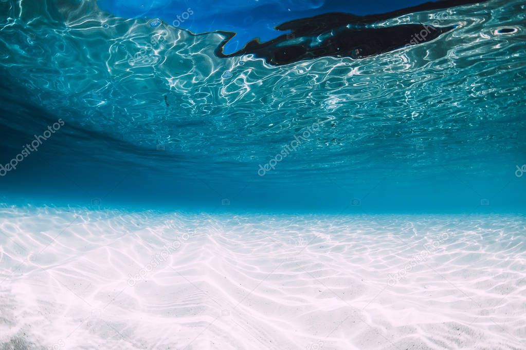 Tropical blue ocean with white sand underwater in Hawaii